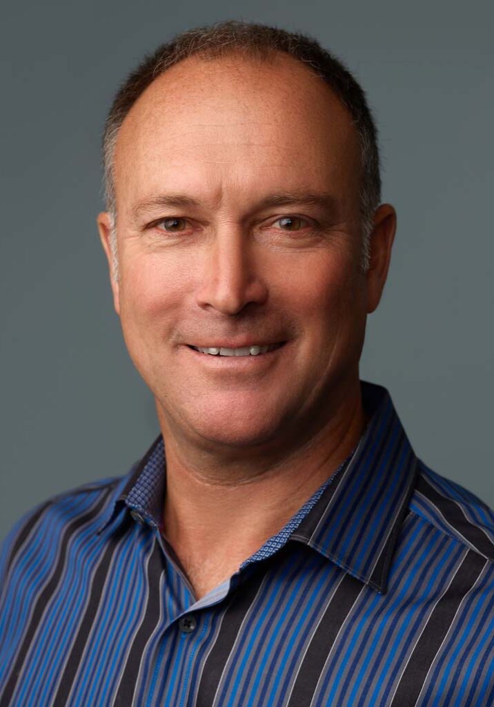 Smiling man in striped blue shirt.