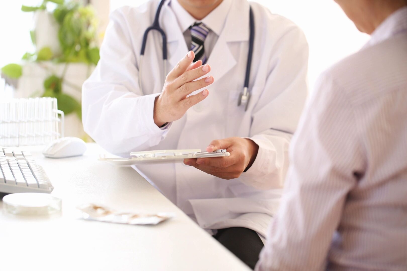 Doctor consulting patient with clipboard discussion.