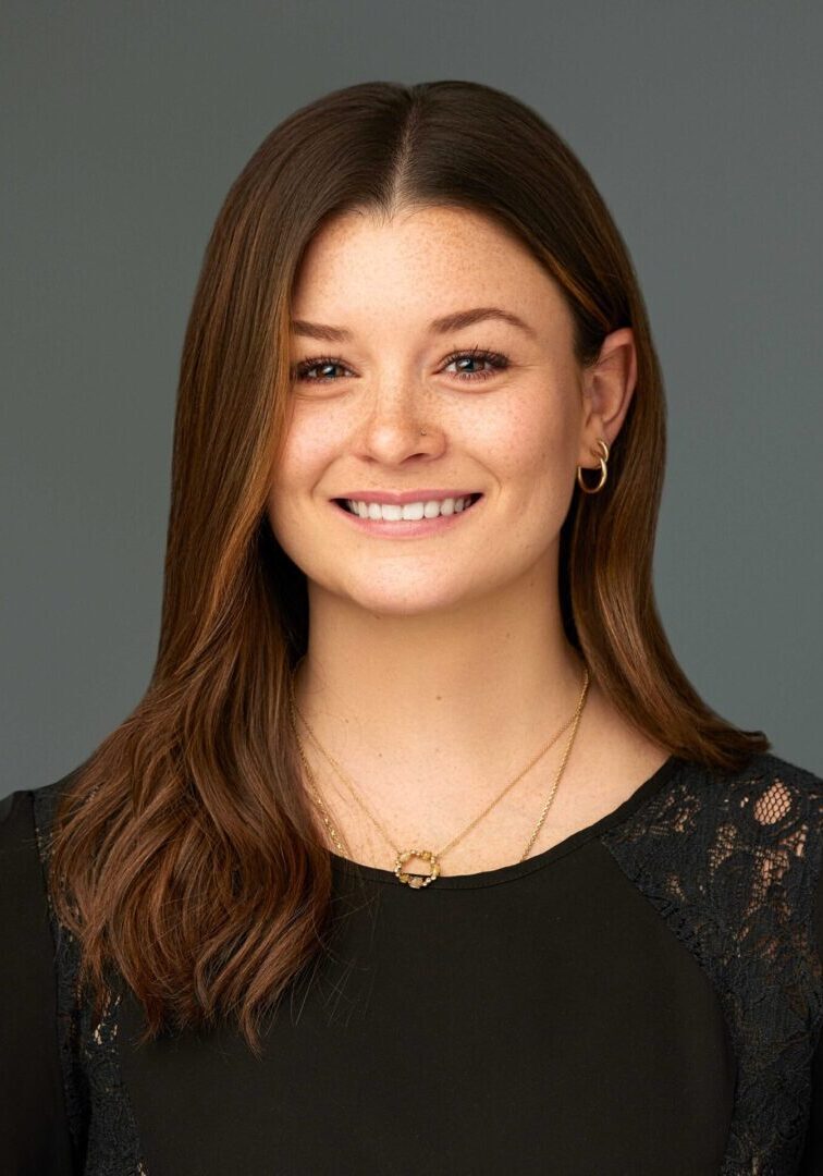 Smiling woman with brown hair and earrings.